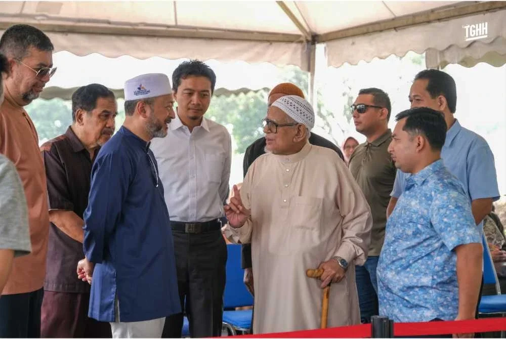 Abdul Hadi turut disantuni anak Allahyarham, Mukhriz ketika berada di kawasan pusara berkenaan.