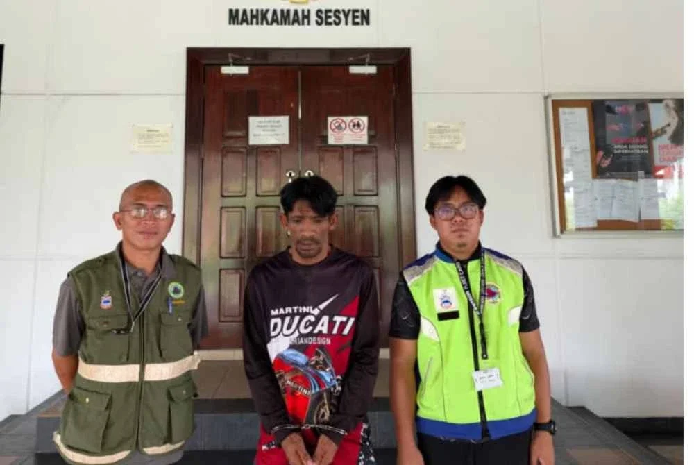 Tertuduh (tengah) ketika dihadapkan ke Mahkamah Lahad Datu.