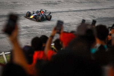 Beberapa penonton merakam aksi pemandu Oracle Red Bull Racing, Max Verstappen pada perlumbaan Formula 1 Gulf Air Bahrain Grand Prix di Litar Antarabangsa Sepang. Foto: Bernama