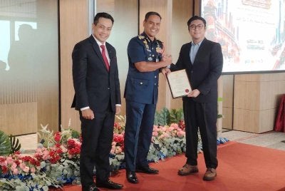 Nor Hisham (tengah) menyerahkan sijil perakuan kepada penerima FSM bagi kumpulan pertama di Menara Merdeka Maybank, Kuala Lumpur pada Selasa.