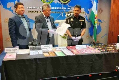 Zakaria (tengah) menunjukkan barang yang dirampas.