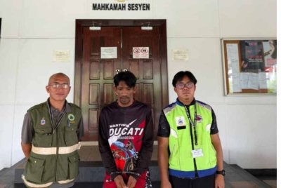 Tertuduh (tengah) ketika dihadapkan ke Mahkamah Lahad Datu.
