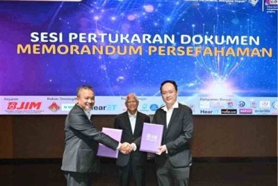 Profesor Datuk’ Dr. Shaiful Bahari Ismail (kiri) dan Tan Kian Boon, JP (kanan) bertukar dokumen MoU antara USM dan Malvest Group Sdn Bhd, disaksikan Profesor Emeritus Datuk’ Dr. Hassan Said (tengah