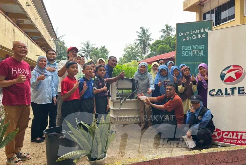 Pihak sekolah yang menunjukkan ikan kepada rombongan kakitangan Caltex ke sekolah mereka.
