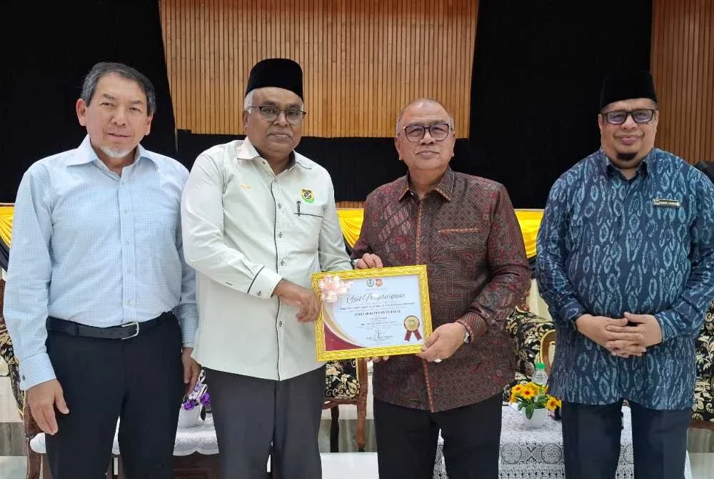Muhammed Mosin (dua dari kiri) menerima Sijil Penghargaan daripada Mohd Zolkafly bagi mewakili peserta Seminar Kesedaran Halal Bagi Pengusaha Restoran Nasi Kandar Negeri Perak di Institut Tadbiran Islam Perak (INTIM), Ipoh pada Khamis.