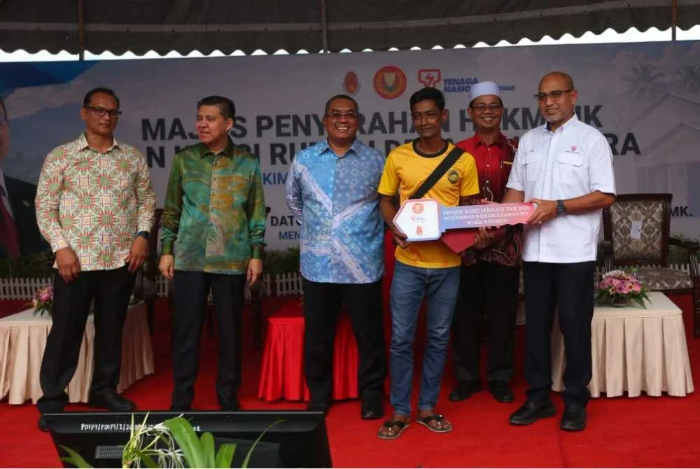 Sanusi (tiga dari kiri) hadir pada Majlis Penyerahan Hakmilik dan Kunci Rumah Desa Sejahtera Perik, Mukim Kurong Hitam, Kuala Nerang pada Khamis.