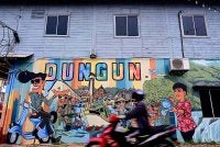 Mural yang memaparkan pelbagai ikon dan kehidupan masyarakat di sebuah kedai kayu ketika tinjauan di Kuala Dungun. - Bernama