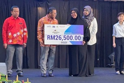 Amirudin (dua dari kiri) menyerahkan sumbangan kepada salah seorang penerima pada Program Jelajah Sejahtera Madani SIKR 3.0 di Shah Alam pada Khamis.