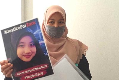 Noraidah menunjukkan poster Justice for Zara. Gambar fail 