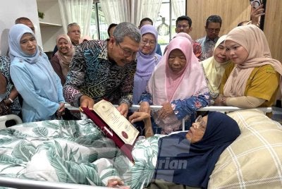 Wan Ahmad (dua dari kiri) menyampaikan sijil penghargaan atas jasa dan perkhidmatan kepada Siti Zaitun (kanan) pada Khamis.