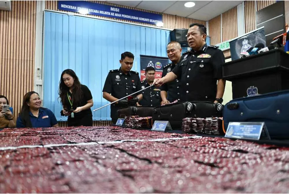 Saifullizan (kanan) menunjukkan dadah yang dirampas pada sidang media di Ibu Pejabat Polis Kontinjen Sarawak hari ini. - Foto: Bernama