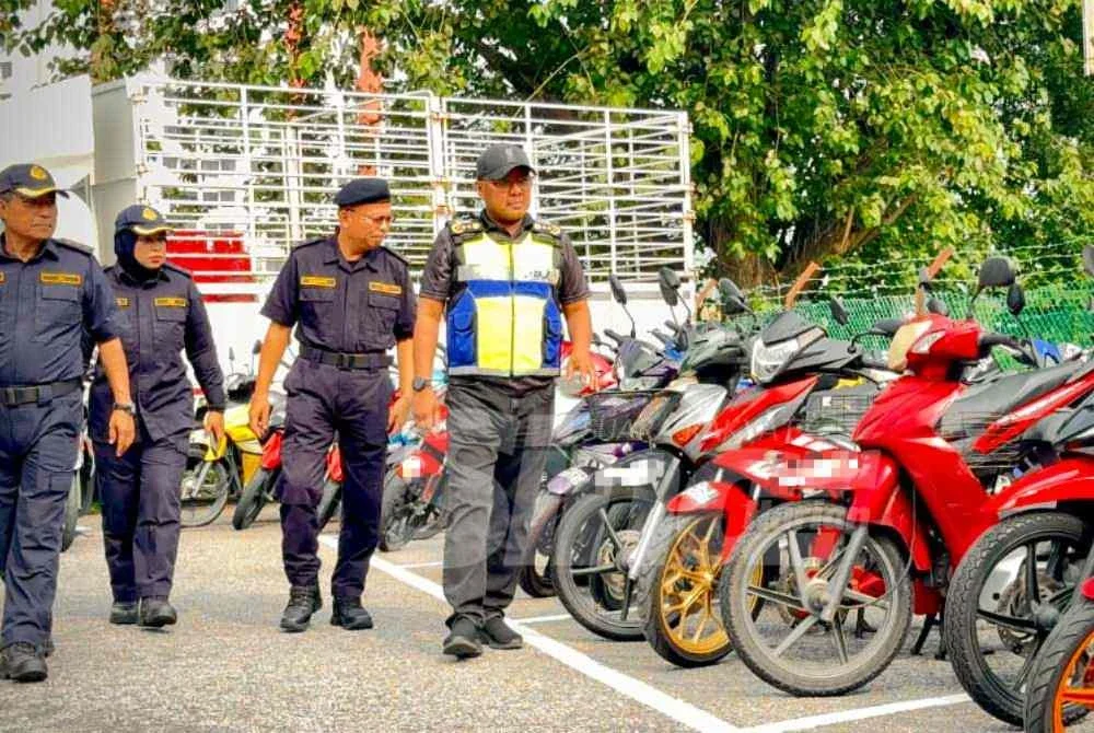 Zulkifly (kanan) memeriksa motosikal yang disita dalam Operasi PeWA yang dijalankan pada awal pagi Jumaat.