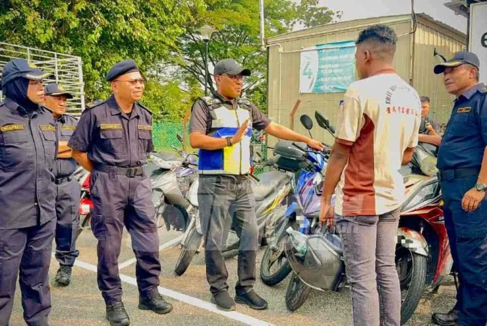 Zulkifly (dua dari kanan) menyoal siasat lelaki Bangladesh yang disita motosikalnya.