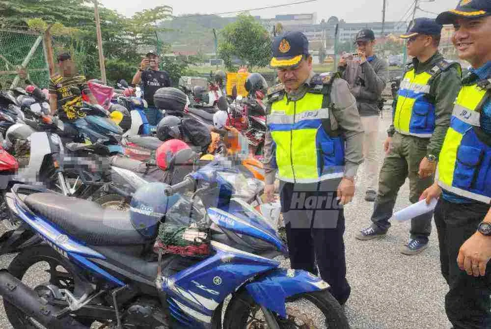 Ahmad Kamarunzaman melihat motosikal yang disita menerusi Op Pewa di sekitar Meru pada Jumaat.