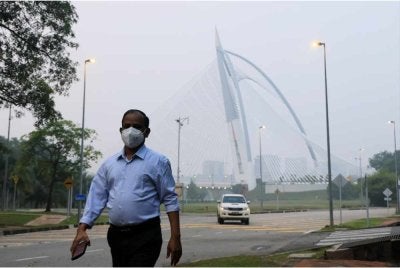 Seorang pejalan kaki memakai pelitup muka ketika tinjauan di Putrajaya susulan keadaan jerebu, hari ini. - Foto: Bernama