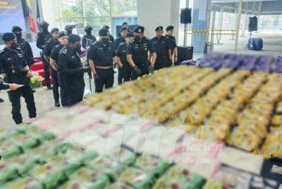 Hussein menunjukkan dadah yang dirampas menerusi Op Tebuan. 
