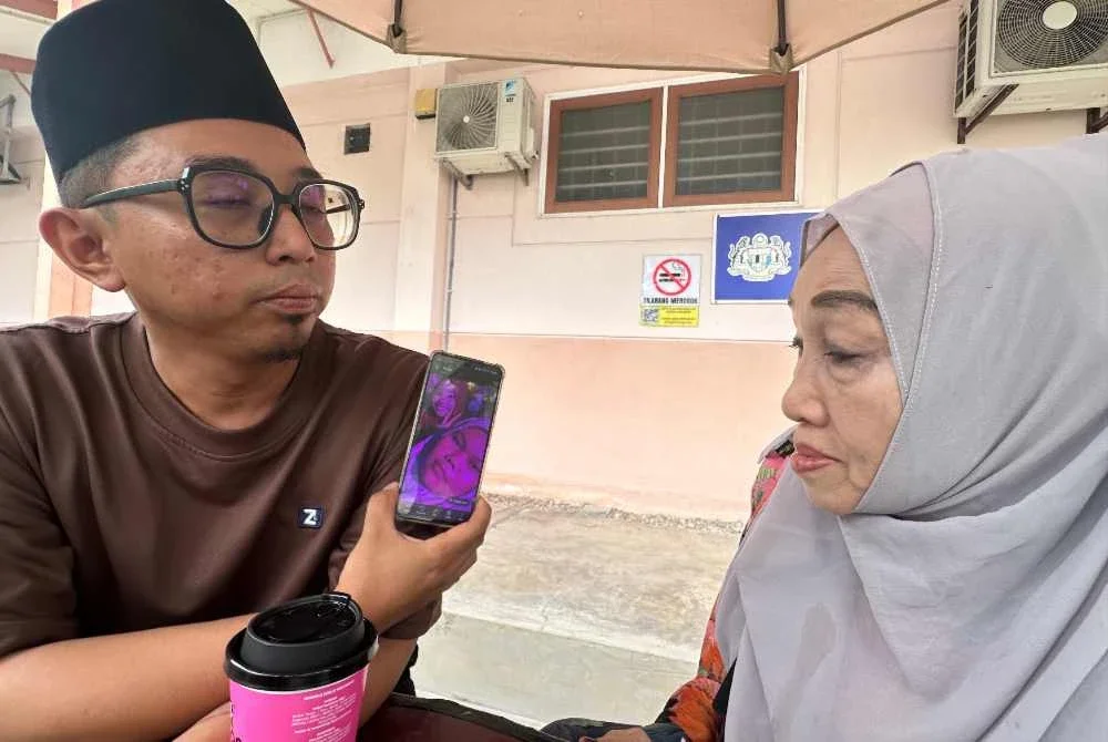 Hamidah dan anaknya, Haisyam menunjukkan gambar kenangan Batrisya serta Maisarah
