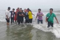 Pasukan bomba membawa mayat mangsa yang ditemukan lemas di Pantai Sepat, Jalan Kuantan-Pekan, di sini pada Sabtu.