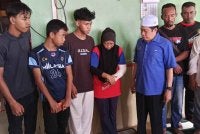 Julaiha (empat dari kiri) bersama suami, Norlizan (dua dari kanan) menerima kunjungan Ahmad Maslan (tiga dari kanan) di Kampung Parit Haji Siraj, Pontian pada Sabtu.