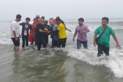 Pasukan bomba membawa mayat mangsa yang ditemukan lemas di Pantai Sepat, Jalan Kuantan-Pekan, di sini pada Sabtu.