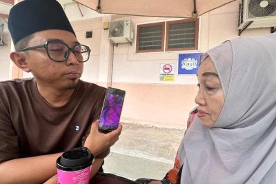 Hamidah dan anaknya, Haisyam menunjukkan gambar kenangan Batrisya serta Maisarah