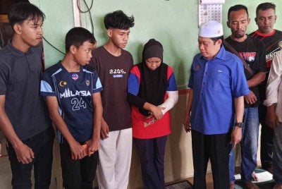 Julaiha (empat dari kiri) bersama suami, Norlizan (dua dari kanan) menerima kunjungan Ahmad Maslan (tiga dari kanan) di Kampung Parit Haji Siraj, Pontian pada Sabtu.
