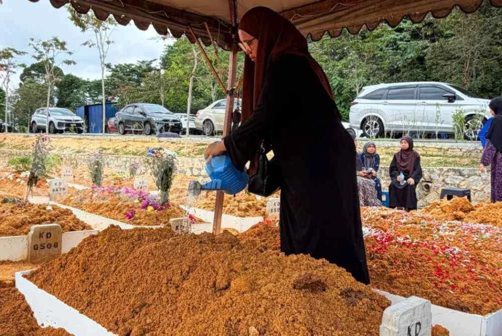 Siti Sarah menyiram pusara ibu tercinta.