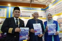 Dari kiri: Lukmanul Hakim, Md Daud dan Ida Riswana menunjukkan risalah mengenai pakej haji 2027 yang ditawarkan Andalusia Travel & Tours Sdn Bhd.