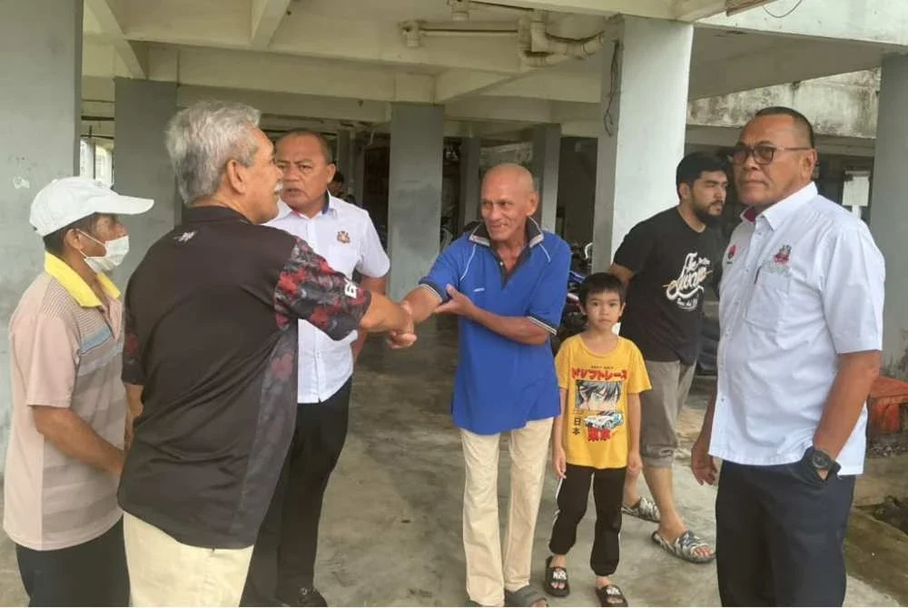 Pandak (kanan) bertemu penduduk di flat Lima Kedai.