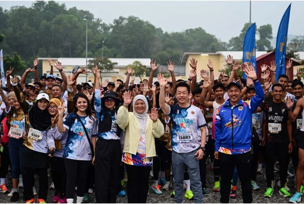 Aziam (tengah) dan Francis (dua dari kanan) bergambar bersama peserta pada program Mesra Run 2.0. Foto: Bernama 