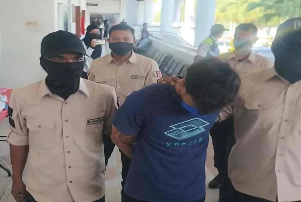 Tertuduh diiringi anggota polis untuk dituduh di Mahkamah Majistret pada Selasa.