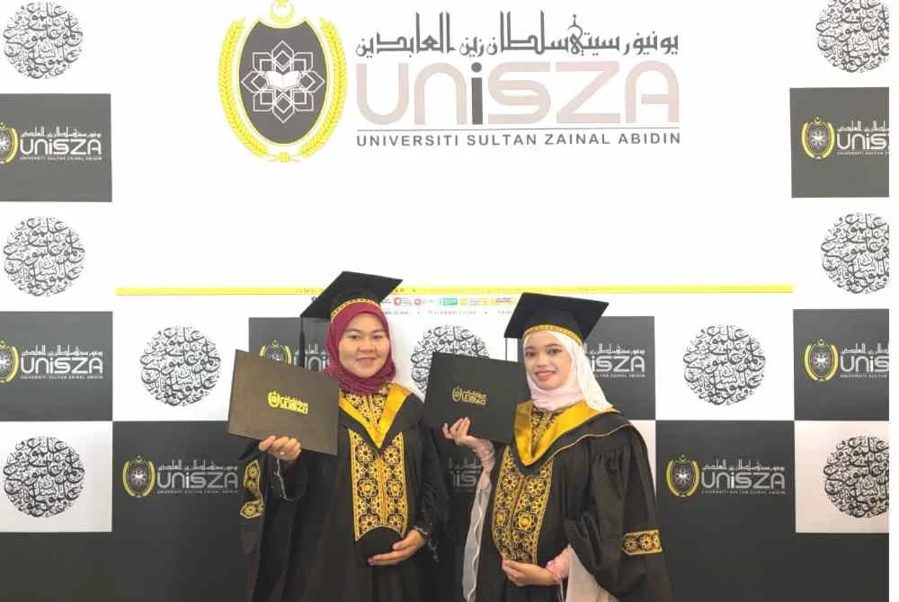 Dua graduan UniSZA, DaniaAinur (kiri) dan Nurhanieza teruja menggenggam Ijazah sempena Majlis Idul Ilmi Konvokesyen UniSZA ke-18 pada Selasa.