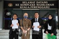Alif Danial (kiri) bersama Tengku Ismail (dua, kiri) dan brisan peguam ketika memfailkan saman terhadap dua institusi perbankan di Mahkamah Tinggi Kuala Terengganu pada Selasa.
