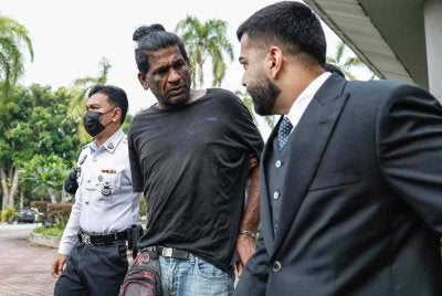 Agilan (tengah) dibawa keluar dari Mahkamah Majistret Shah Alam pada Selasa. - FOTO: Bernama