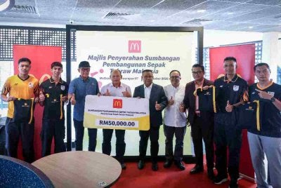 Pengarah Urusan dan Rakan Operasi Tempatan McDonald’s Malaysia, Datuk Azmir Jaafar (tiga, kiri) dan Presiden Persekutuan Sepaktakraw Malaysia (PSM), Datuk Mohd Sumali Reduan (tengah) bergambar bersama para atlet sepak takraw dan jurulatih sempena Majlis Penyerahan Sumbangan Pembangunan Sepak Takraw Malaysia di McDonald's Titiwangsa DT. Foto: Bernama