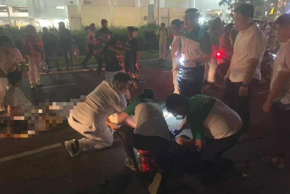 Peserta perarakan membantu tiga mangsa yang terjatuh di atas jalan dipercayai akibat terkena renjatan elektrik semasa menyertai perarakan di jalan utama di Mergong, Alor Setar. Foto tular