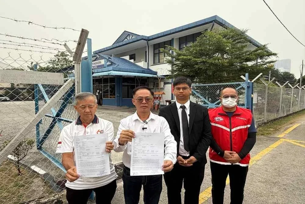 Chee Leong (dua dari kiri) menunjukkan laporan polis dibuat pada Rabu. Foto: Sinar. 