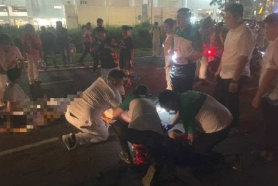 Peserta perarakan membantu tiga mangsa yang terjatuh di atas jalan dipercayai akibat terkena renjatan elektrik semasa menyertai perarakan di jalan utama di Mergong, Alor Setar. Foto tular
