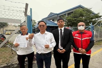 Chee Leong (dua dari kiri) menunjukkan laporan polis dibuat pada Rabu. Foto: Sinar. 