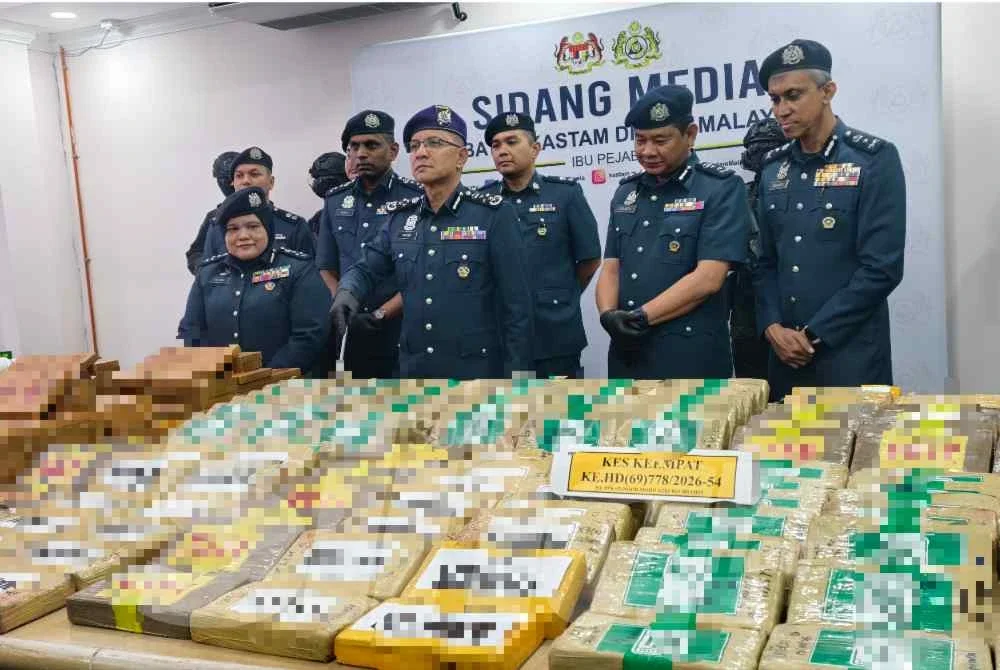 Amran (tengah) menunjukkan dadah yang dirampas dalam empat operasi berasingan