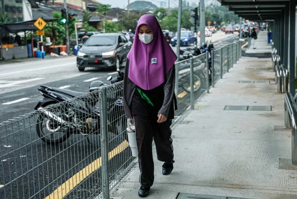 Pelajar yang hadir ke sekolah dilihat mengambil langkah berjaga-jaga dengan memakai pelitup muka walaupun situasi jerebu yang sudah berkurangan ketika tinjauan di sekitar Lembah Keramat. Foto Bernama