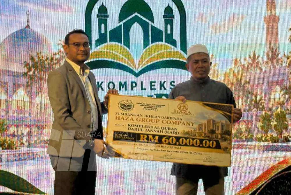 Ridzuan (kiri) menyampaikan cek RM60,000 kepada Johari bagi menjayakan projek KADJ.