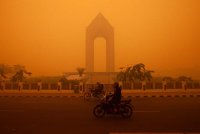 Penunggang motosikal melalui jalan raya pada waktu pagi di Palangkaraya, Kalimantan Tengah pada 14 Oktober 2026, dalam keadaan berjerebu tebal akibat kebakaran hutan dan tanah di kawasan berkenaan. Foto AFP