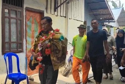 Bapa membawa jenazah bayinya yang meninggal dunia akibat sesak nafas dipercayai berpunca daripada asap kebakaran hutan dan tanah di Samarinda. Foto: Agensi