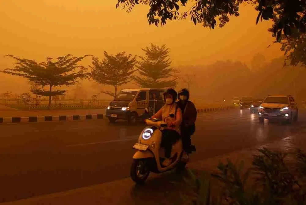 Pengguna jalan raya bergerak dalam keadaan jarak penglihatan terhad akibat jerebu tebal.