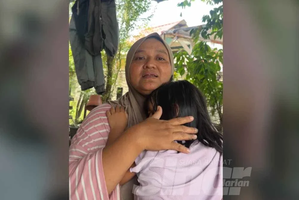 Marliza mendukung anak bongsu mangsa yang sedang sakit demam. FOTO SINAR HARIAN - ADILA SHARINNI WAHID