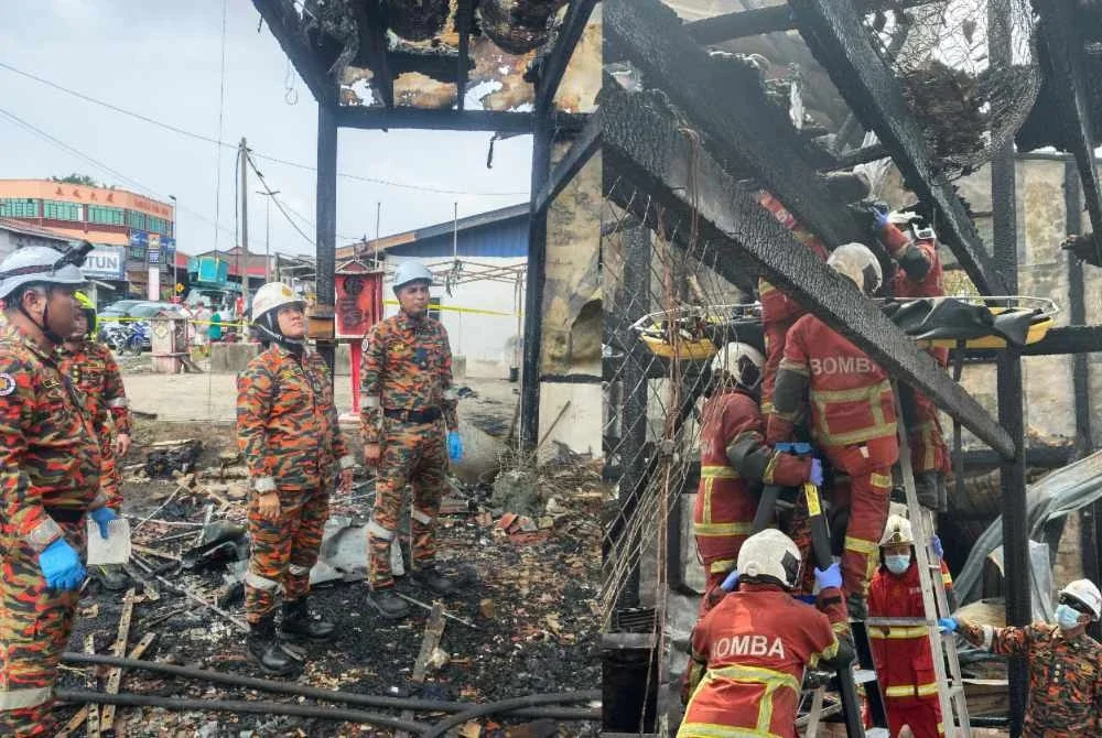 Sayani (dua dari kanan) ketika meninjau lokasi kejadian kebakaran yang mengorbankan dua beradik di Kampung Koh, Sitiawan pada Jumaat.