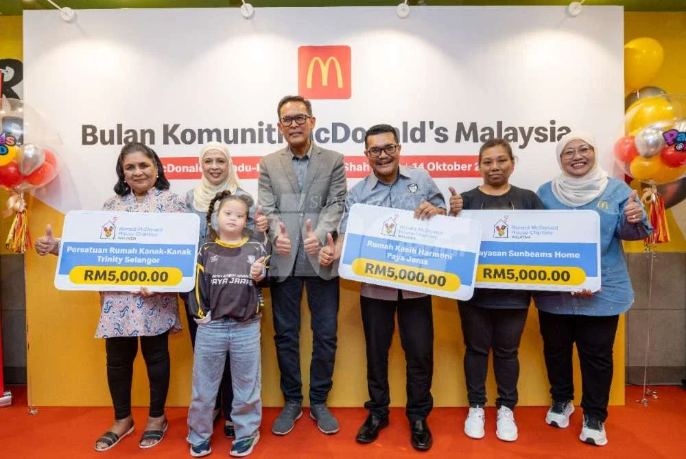 Azmir (empat dari kanan), Melati (lima dari kanan) dan Shamsidar (kanan)
bergambar bersama penerima sumbangan yang diwakili pihak pengurusan rumah
kebajikan terlibat. Foto: Mohd Halim Abdul Wahid