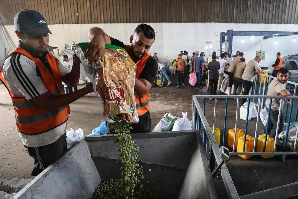 Buah zaitun dituangkan ke dalam mesin untuk diproses di sebuah kilang al-Zawayda, tengah Gaza. - AFP