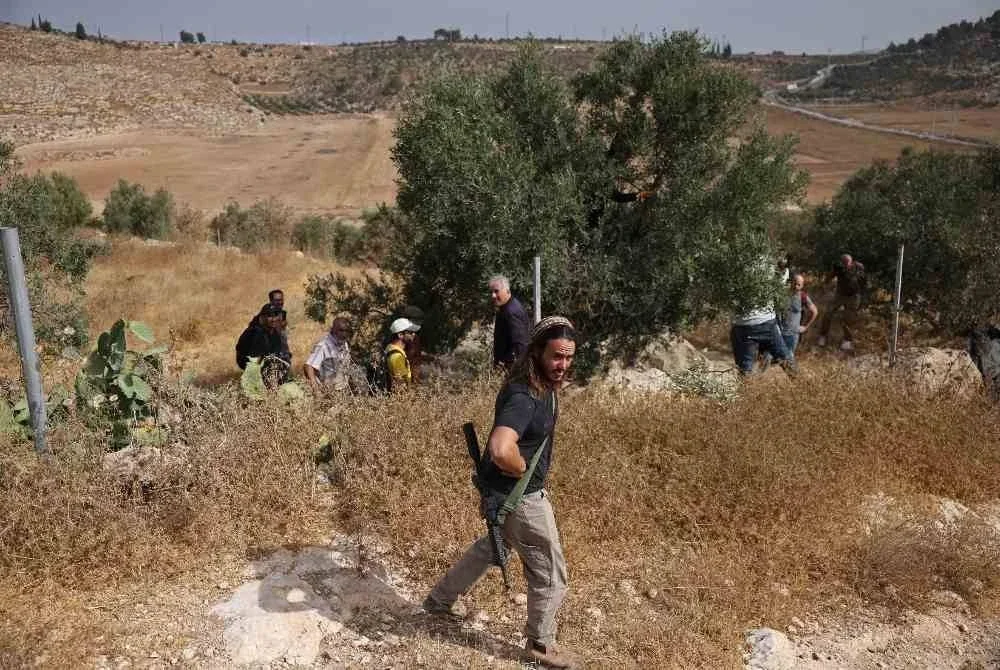 Pelampau Yahudi bersenjata sengaja mencetuskan kekacauan di ladang zaitun di perkampungan Idna berhampiran bandar Hebron. - AFP